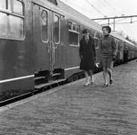 858509 Afbeelding van enkele jonge dames bij een internationale trein langs het perron van het N.S.-station ...